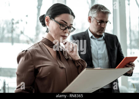 Hohe grauhaarige nach schöner Mann in Brillen Suche beteiligt Stockfoto