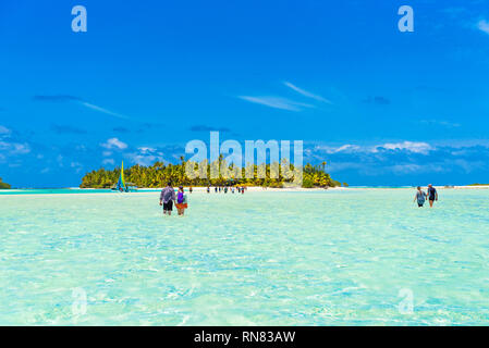 Menschen zu Fuß wahre türkisfarbenen Wasser zu einem Sandstrand der Insel Aitutaki, Cook Inseln, Stockfoto
