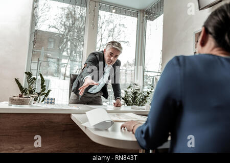 Hohe grauhaarige stattlicher Mann in Brillen Gefühl genervt Stockfoto