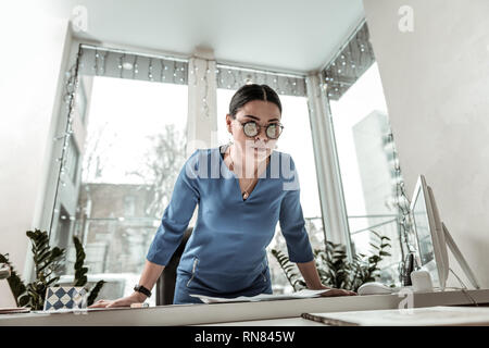 Dunkelhaarige schöne asiatische Frau in einem blauen Hemd das Gefühl irritiert Stockfoto