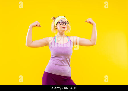 Blonde Frau Brille trägt ihre Muskeln angezeigt Stockfoto