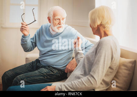 Familie fragen. Von aufmerksamen liebevolle Rentner Gefühl im Sprechen über ernste Themen sitzen auf einem Sofa beteiligt Stockfoto