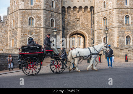 Eine Pferdekutsche vor Windsor Castle gezogen gezogen von zwei weißen Pferden ist beliebt bei Touristen und bietet Fahrten um Windsor. Stockfoto