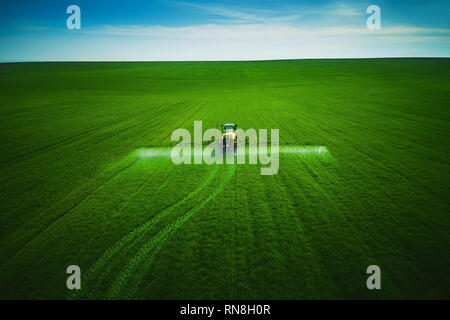 Luftaufnahme von landwirtschaftlichen Traktor Pflügen und Spritzen auf dem Feld. Stockfoto