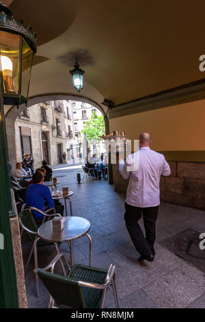 Kellner mit einem Tablett in typischen Chocolatería San Ginés, Schokolade Cafe, Pasadizo de San Ginés,, Madrid, Spanien Stockfoto