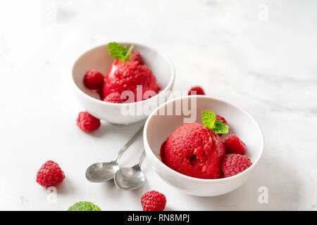 Himbeersorbet in zwei Tassen auf weißen Tisch Stockfoto