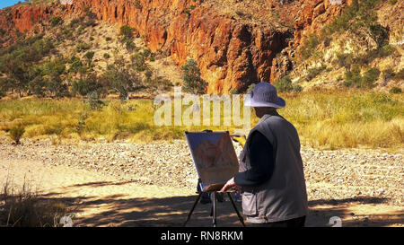 Nahaufnahme einer Künstlerin Malerei Glen Helen Gorge in den west macdonnell Ranges in der Nähe von Alice Springs. Stockfoto