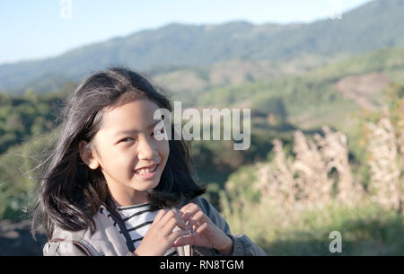 Asiatische Mädchen das Herz Form und lächelnd mit Reisen auf die Berge. Stockfoto
