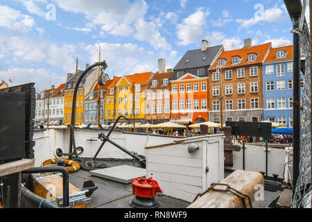 Die bunten historischen Gebäude entlang der Nyhavn Kanal steigen über das Deck eines angedockten Segelboot in Kopenhagen Dänemark Stockfoto