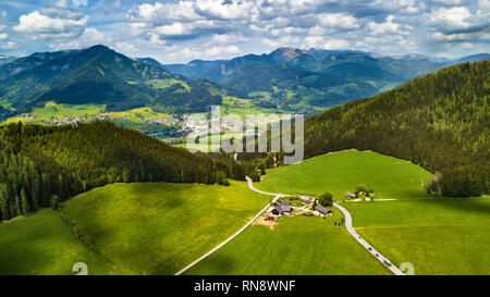 Frühling Reisen in Österreich. Grüne Felder und Wiesen in Alpen. Straße in der alpinen Landschaft. Stockfoto