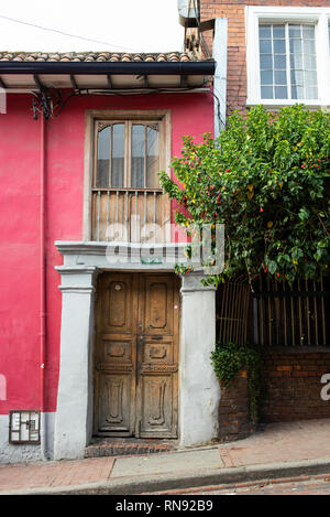 Helle koloniale Fassade des Gebäudes mit alten hölzernen Tür. La Candelaria, Bogota, Kolumbien. Sep 2018 Stockfoto