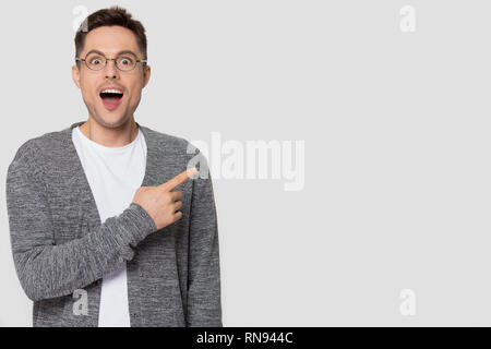 Erstaunt Mann in Gläser Zeigefinger beiseite an Kamera suchen Stockfoto