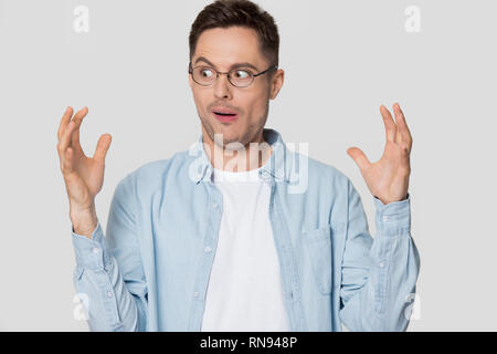 Lustige schockiert junge Mann an Hände sichtbar etwas Gewaltiges suchen Stockfoto