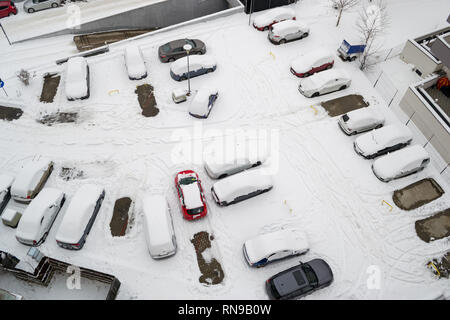 Luftaufnahme eines städtischen Parkplatz in einem Wohngebiet, nach einem schweren Schnee, mit Autos mit Schnee und ein paar leere Parkplätze gedeckt. Januar 2019 Stockfoto