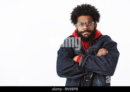 Taille-up Shot von intensiven und gestört, düsteren wütend african american bärtigen Mann in Gläsern mit Urteil und Missbilligung runzelte die Stirn und Schmollen Stockfoto