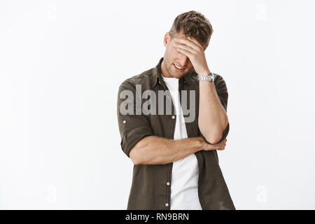 Peinlich und unangenehm stattlichen ex - Freund versuchen, hinter der Hand verstecken wie facepalm Geste so Mädchen würde ihn nicht erkennen, lächelnd von Stress Stockfoto