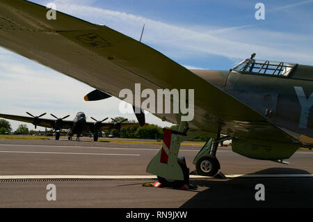 Royal Air Force die Schlacht um England Memorial Flight Hawker Hurricane Jagdflugzeug framing Avro Lancaster Bomber. Zweiten Weltkrieg Flugzeuge Stockfoto