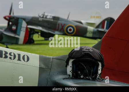 Royal Air Force die Schlacht um England's Memorial Flight Pilot Helm mit Hawker Hurricane Kampfflugzeug. Bereit. Zweiten Weltkrieg Flugzeuge Stockfoto