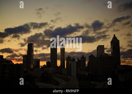 Eine dramatische Silhouette der Skyline von Georgia in Atlanta, die in einem goldenen Sonnenuntergang auftaucht. Stockfoto
