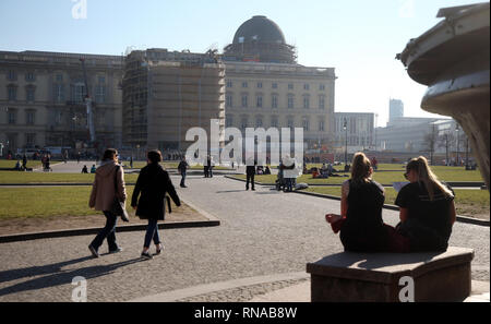 Berlin, Deutschland. 18 Feb, 2019. Mit strahlendem Sonnenschein und Temperaturen um 15 Grad Celsius, Menschen laufen durch den Lustgarten in Berlin-Mitte und die warmen Strahlen der Sonne genießen. Nach Angaben der Meteorologen in den kommenden Tagen weiter Wetter-Bestimmung mit milden Temperaturen. Im Hintergrund der Neubau des Berliner Schlosses. Quelle: Wolfgang Kumm/dpa/Alamy leben Nachrichten Stockfoto