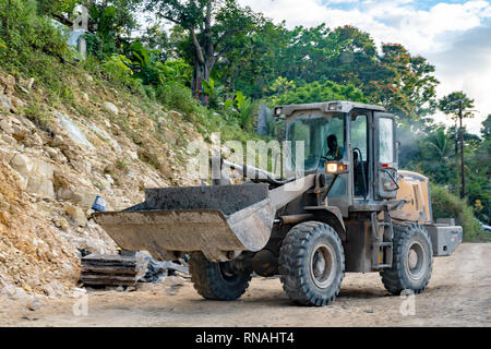 Planierraupe in Betrieb von männlichen Bauarbeiter auf der Straße Baustelle in ländlichen Landschaft Stockfoto