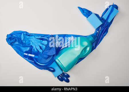 Blick von oben auf die whale Abbildung aus Gummi Handschuhe, Kunststoff Teller, Tassen, Schwämme, Löffel, Tasche und Flasche isoliert auf weißem Stockfoto