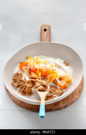 Gesundes Frühstück. Multigrain Flakes mit griechischen Joghurt und Früchte Mango und Papaya Stockfoto