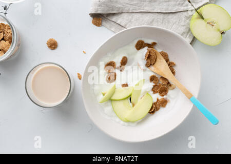 Gesundes Frühstück Multigrain Flakes mit Apple, griechischem Joghurt und hafermilch Draufsicht Stockfoto