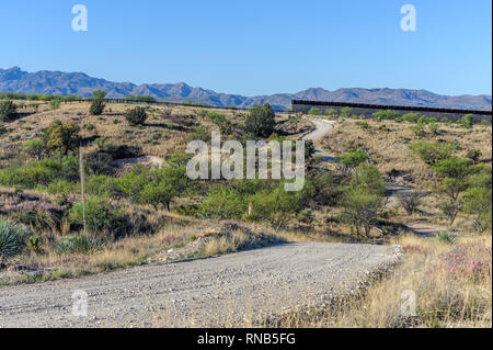 Uns Grenzzaun, zeigt hohe personensperre auf der rechten Seite an seinem östlichen Ende 7 Meilen östlich von Nogales AZ., mit Kraftfahrzeug Barriere" auf der linken Seite; April 2018 Stockfoto