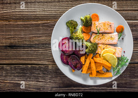 Gourmet Teller mit gekochtem Gemüse, gegrillter Lachs und Pommes Frites. Abendessen auf Platte, Ansicht von oben Stockfoto