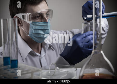 Professionelle Wissenschaftler ein Reagenzglas und Tablet während der Forschung Stockfoto