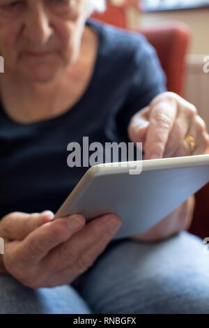 Nahaufnahme der älteren Frau mit digitalen Tablette zu Hause Stockfoto
