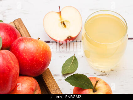 Glas frischen Bio Apfelsaft mit roten Äpfeln in vintage Box auf Holz Hintergrund Stockfoto