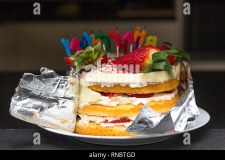 Geburtstag Kuchen enthüllt Schichten aus Erdbeere und Sahne mit der Rückseite der Kuchen Kerzen Rückwärtsfahrt mit teilweise entfernt Sperrschichthülle schmeckte super! Stockfoto