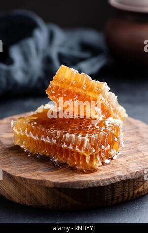 Waben auf Holzbrett. Raw Honig, natürliches Bio Honig. Selektiver Fokus, rustikalen Stil Stockfoto