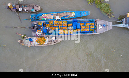 Luftaufnahme, Ansicht von oben Cai Rang Floating Market. Touristen, die Menschen kaufen und verkaufen Lebensmittel, Gemüse, Früchte auf dem Boot, Schiff am Fluss markt Stockfoto