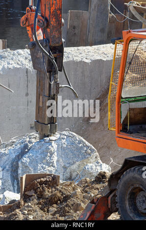 Abbruchbagger hydraulikhammer zwischen zwei Stücke von nur unterteilt Betonklotz ruhen Stockfoto