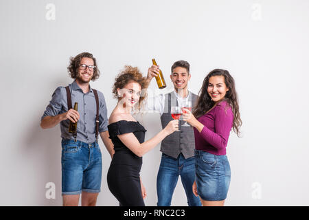 Porträt der jungen Gruppe von Freunden, die in einem Studio, Flaschen und Gläser. Stockfoto