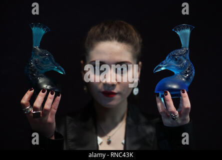 Bonhams Mitarbeiter Emily Mayson halten zwei "Tête de Bréhat' Auto Maskottchen in dem Jahr 1928, ein aus blauem Glas (rechts) und die andere von Türkisfarbenem Glas, und sowohl zwischen £ 15.000 geschätzt - £ 25.000, während ein Foto für eine private Sammlung von Meisterwerken Glasmacher René Lalique, bevor es an der Auktion bei Bonhams in London angeboten wird. Stockfoto