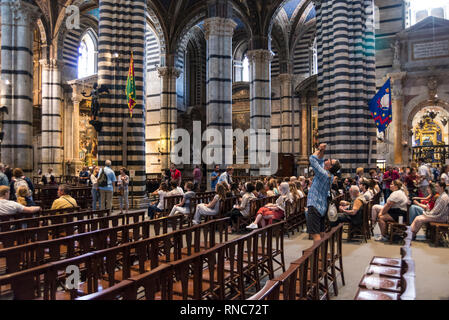 Touristen im Inneren des Duomo di Siena (Siena), Toskana, Italien Stockfoto