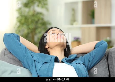 Lady ruhend sitzen auf eine bequeme Couch im Wohnzimmer zu Hause. Stockfoto