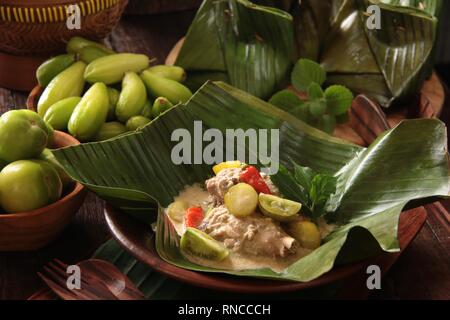 Garang Asem Ayam. Traditionellen javanischen Schüssel, würzige Chicken Curry im Bananenblatt Beutel. Stockfoto