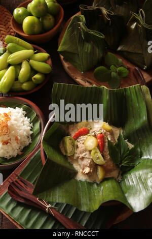 Garang Asem Ayam. Traditionellen javanischen Schüssel, würzige Chicken Curry im Bananenblatt Beutel. Stockfoto