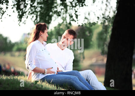 Schwangere Frau mit Mann im Park. Riendly, freundliche Familie Picknicken. Stockfoto