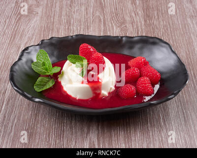 Vanilla Bean Pannacotta mit Himbeersauce, frische Himbeeren und Minze Stockfoto