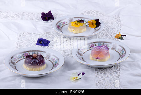 Einzigartigen japanischen Dessert Havaro von Gelee und Bayrisch Creme mit essbaren violetten Blüten. Gelatine gesunde Ernährung Dessert. Stockfoto