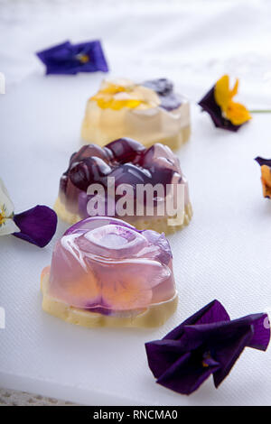 Einzigartigen japanischen Dessert Havaro von Gelee und Bayrisch Creme mit essbaren violetten Blüten. Gelatine gesunde Ernährung Dessert. Stockfoto