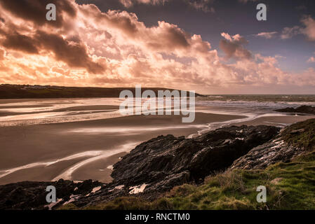 Ein spektakulärer Sonnenuntergang über Crantock Strand bei Ebbe in Newquay Cornwall. Stockfoto