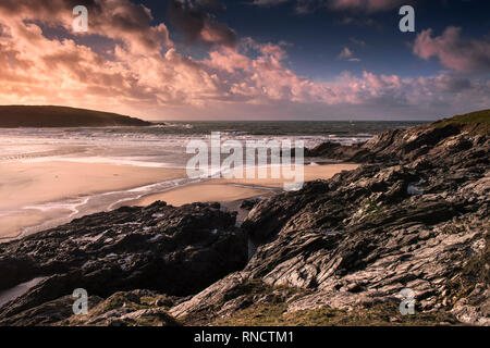 Ein spektakulärer Sonnenuntergang über Crantock Strand bei Ebbe in Newquay Cornwall. Stockfoto