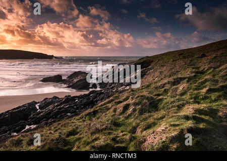 Ein spektakulärer Sonnenuntergang über der zerklüfteten Küste um crantock Strand bei Ebbe in Newquay Cornwall. Stockfoto